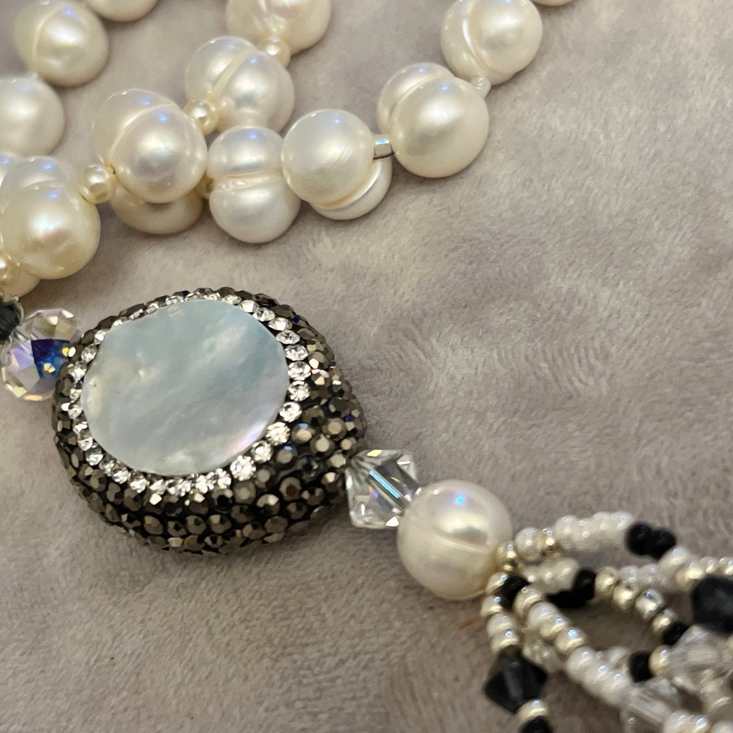 Pearl with elements in Mother of Pearl surrounded by crystals