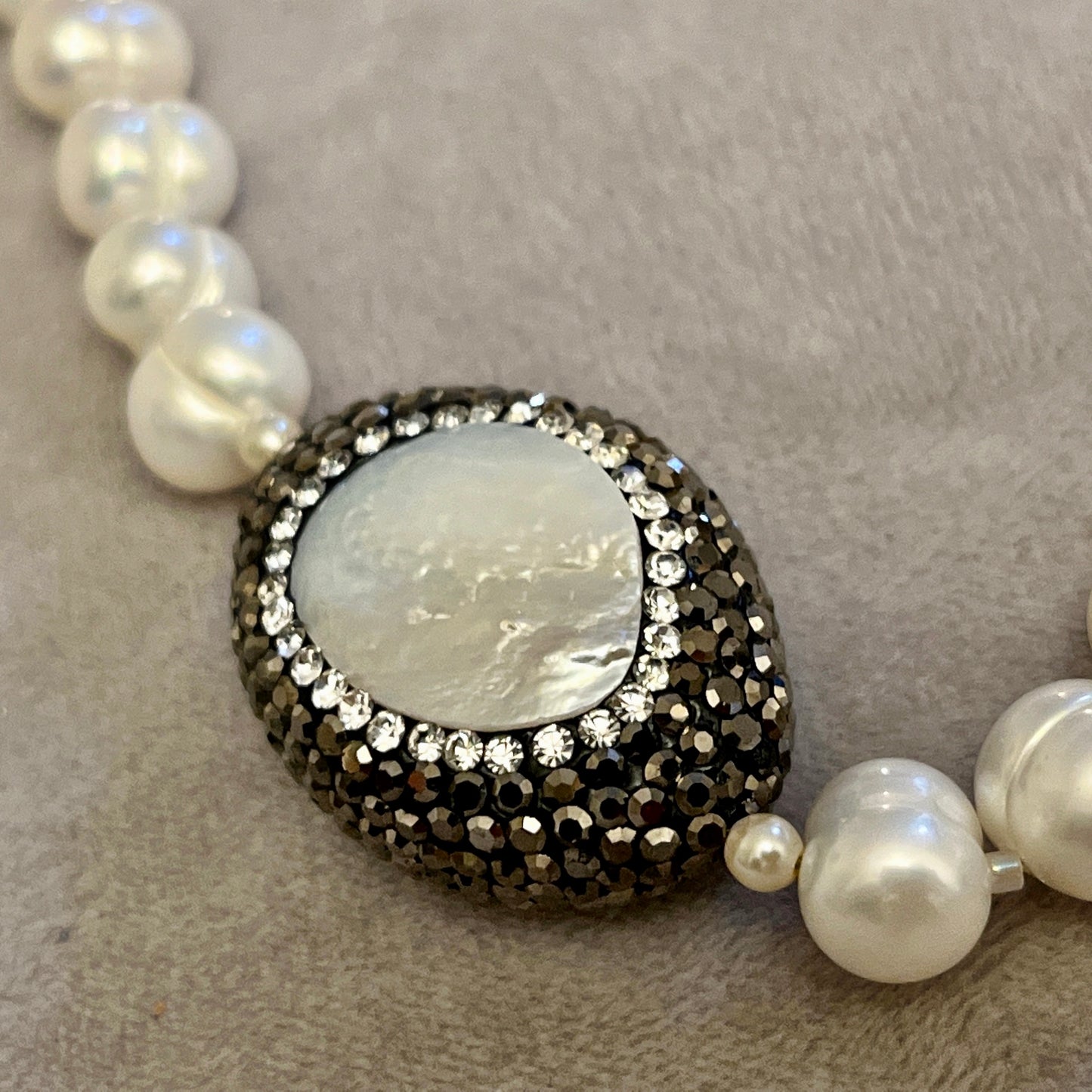 Pearl with elements in Mother of Pearl surrounded by crystals