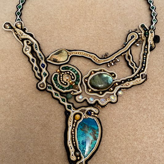 Picture showing the finished statement necklace - a large piece including Labradorite and Azurite cabachons alongs ide smaller gems, seed beads and Swarovski Crystals with Soutache